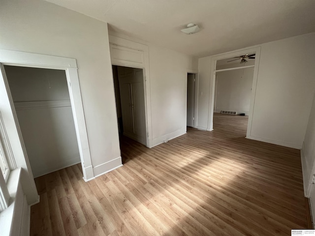 unfurnished bedroom featuring a closet, light wood-type flooring, and baseboards