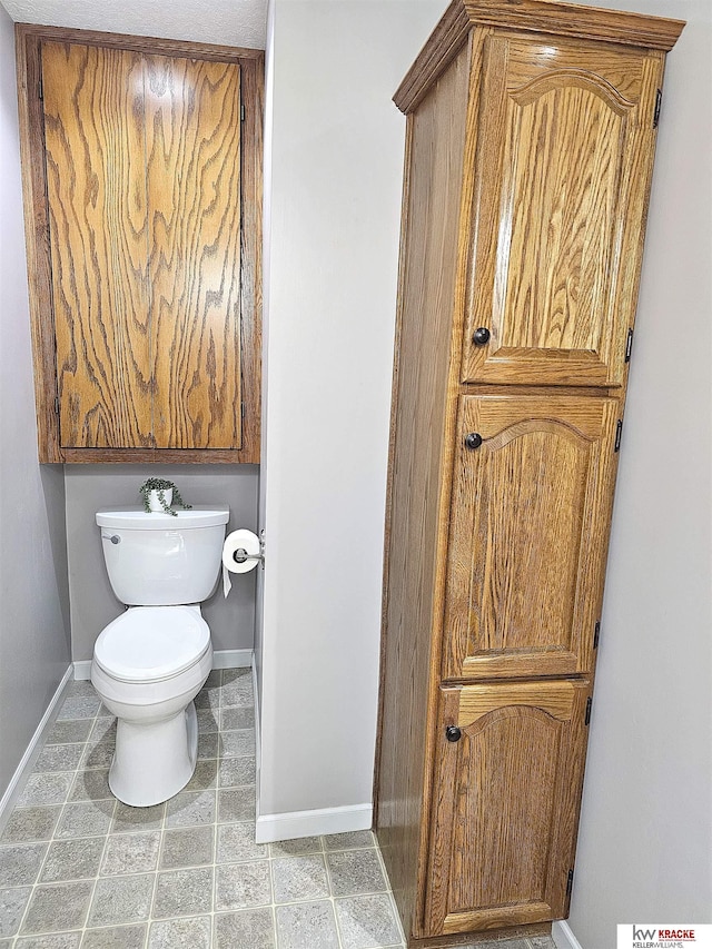 bathroom with baseboards and toilet