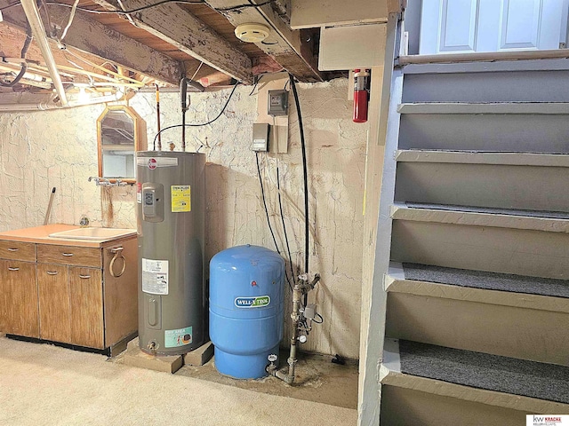 utility room with water heater and a sink