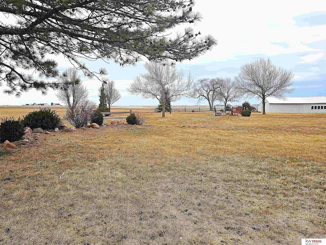 view of yard with a rural view and fence