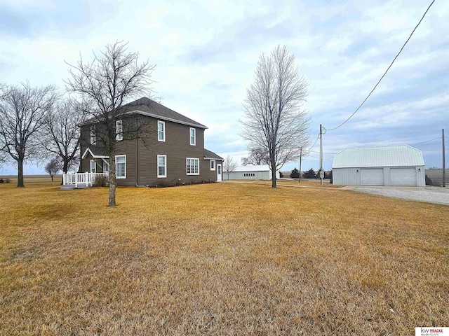 view of yard with a detached garage and an outdoor structure