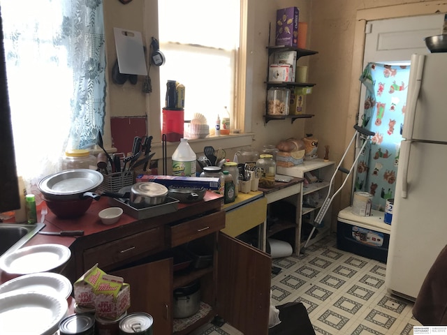 kitchen featuring freestanding refrigerator and open shelves