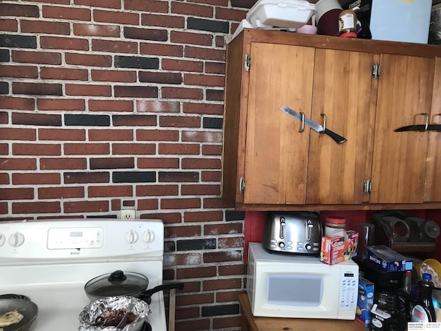 interior details featuring white microwave, brown cabinetry, and washer / dryer