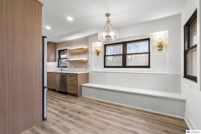 kitchen featuring light countertops, appliances with stainless steel finishes, a healthy amount of sunlight, and light wood-style floors