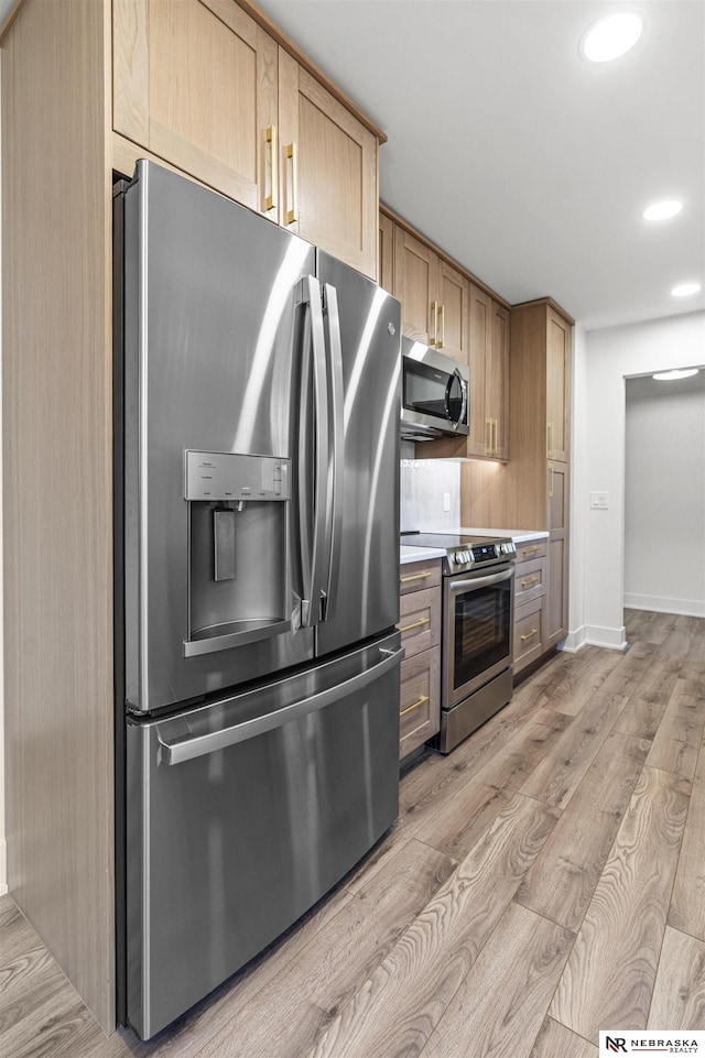 kitchen with stainless steel appliances, tasteful backsplash, light countertops, light wood-style flooring, and light brown cabinetry