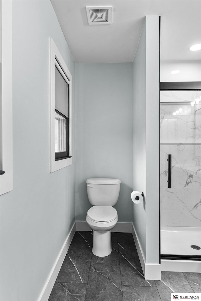 bathroom featuring toilet, baseboards, a marble finish shower, and visible vents