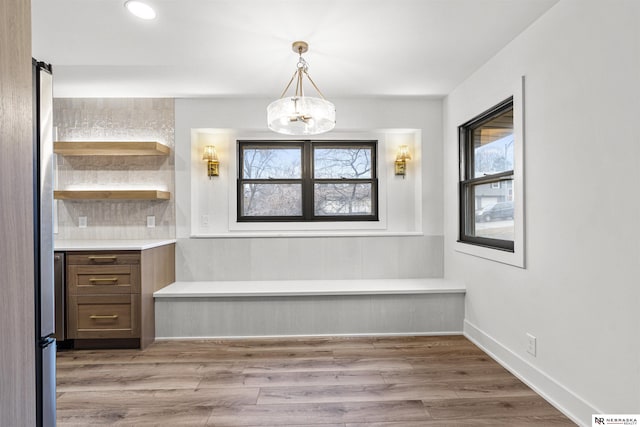 unfurnished dining area with baseboards, a chandelier, wood finished floors, and recessed lighting