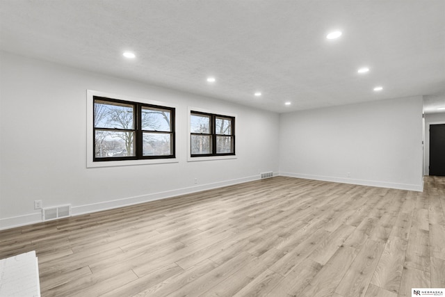 spare room featuring light wood-style flooring, visible vents, baseboards, and recessed lighting