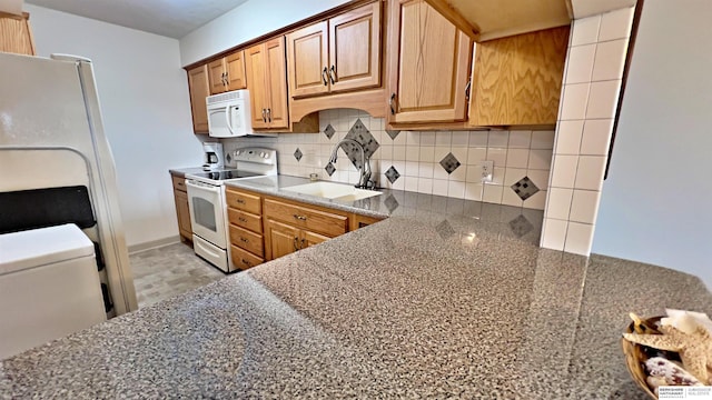 kitchen featuring white appliances, decorative backsplash, and a sink