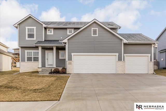 view of front of property with driveway, a shingled roof, an attached garage, and a front yard