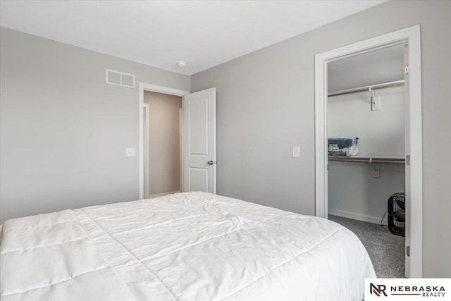 bedroom featuring carpet floors, a walk in closet, a closet, and visible vents