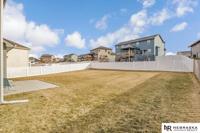 view of yard with a patio area, a fenced backyard, and a residential view