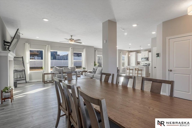 dining space featuring ceiling fan, a textured ceiling, recessed lighting, wood finished floors, and baseboards