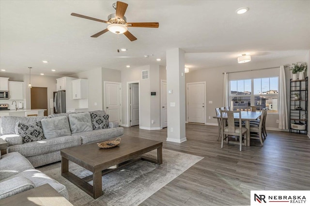 living area with baseboards, visible vents, a ceiling fan, wood finished floors, and recessed lighting