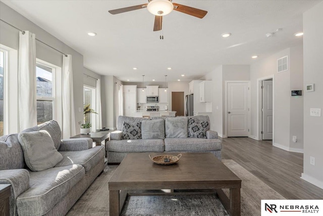 living area with ceiling fan, recessed lighting, visible vents, baseboards, and light wood-style floors