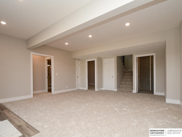 empty room featuring recessed lighting, light carpet, stairway, and baseboards