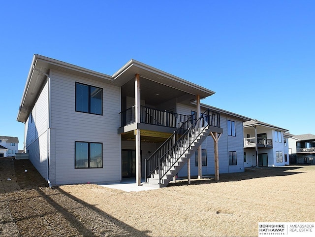 rear view of property featuring a patio area and stairway