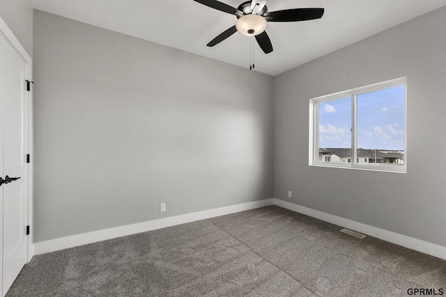 carpeted empty room with a ceiling fan, visible vents, and baseboards