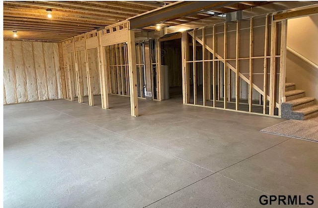 miscellaneous room featuring stairs and concrete floors