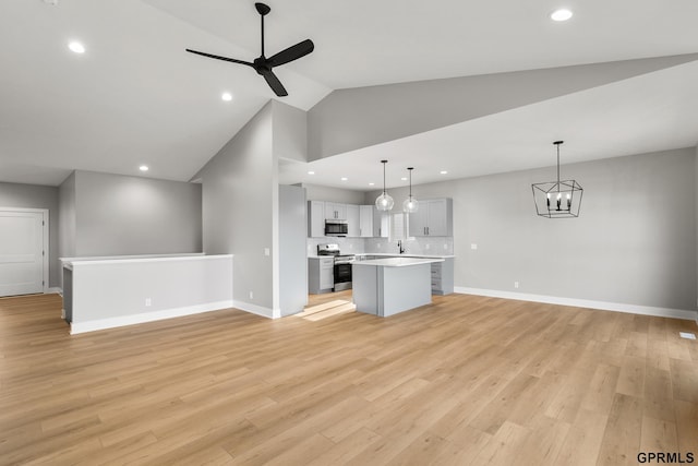 unfurnished living room with ceiling fan with notable chandelier, recessed lighting, light wood-style flooring, and baseboards