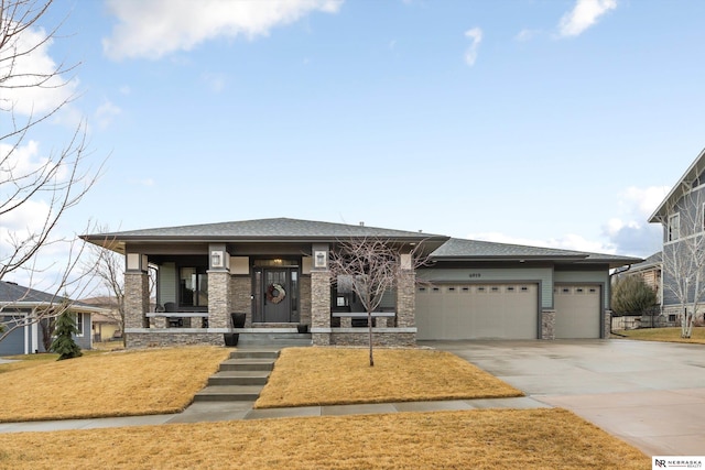 6919 Wildrye Rd, Lincoln, NE 68521 - prairie-style home featuring roof with shingles, a porch, a garage, stone siding, and driveway