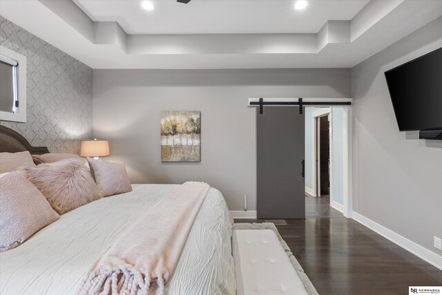 6919 Wildrye Rd, Lincoln, NE 68521 - bedroom featuring a barn door, recessed lighting, an accent wall, wood finished floors, and baseboards