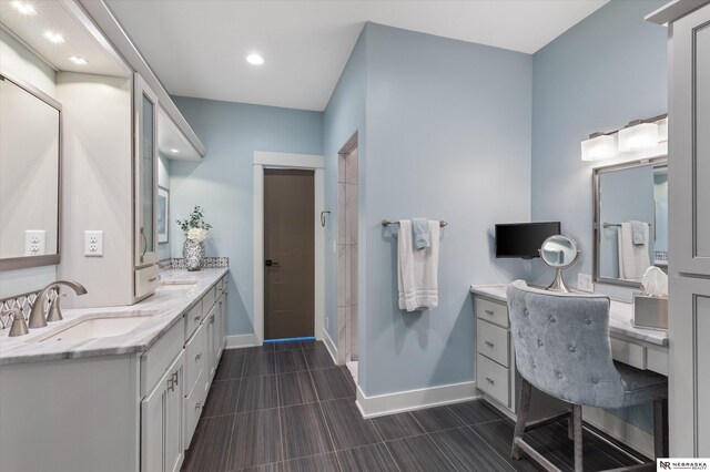 6919 Wildrye Rd, Lincoln, NE 68521 - bathroom featuring tile patterned flooring, baseboards, a sink, and tiled shower