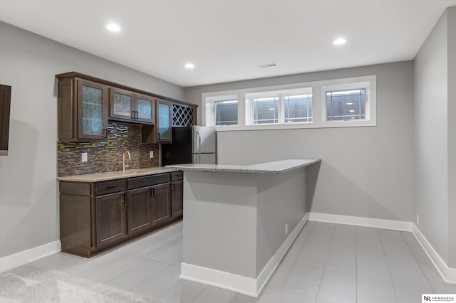 6919 Wildrye Rd, Lincoln, NE 68521 - bar with visible vents, baseboards, freestanding refrigerator, backsplash, and recessed lighting