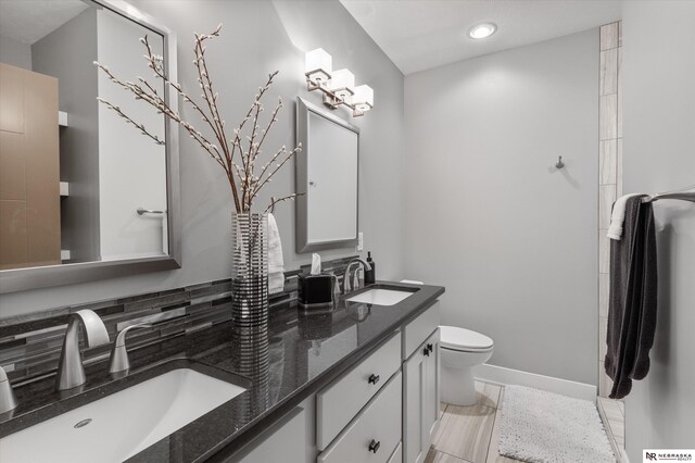 6919 Wildrye Rd, Lincoln, NE 68521 - full bath with toilet, double vanity, baseboards, and a sink