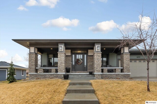 6919 Wildrye Rd, Lincoln, NE 68521 - prairie-style home featuring a garage, stone siding, a front lawn, and covered porch