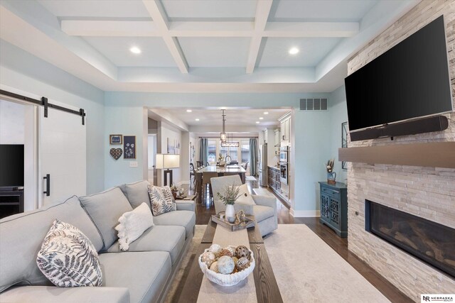 6919 Wildrye Rd, Lincoln, NE 68521 - living area with a barn door, visible vents, coffered ceiling, dark wood finished floors, and beam ceiling
