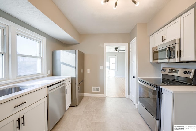 kitchen featuring white cabinetry, visible vents, stainless steel appliances, and a wealth of natural light