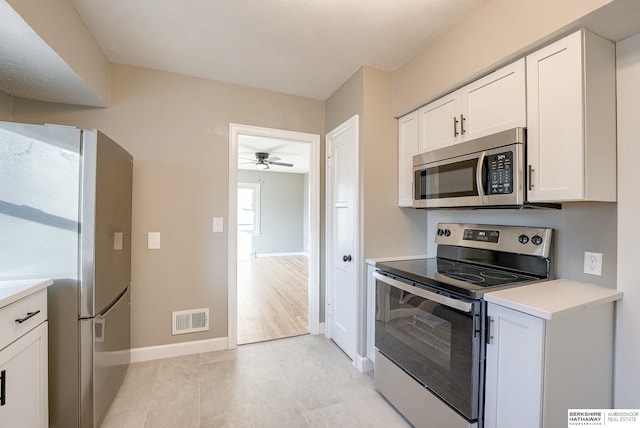 kitchen with baseboards, visible vents, white cabinets, appliances with stainless steel finishes, and light countertops