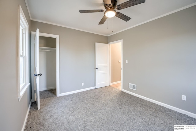 unfurnished bedroom with baseboards, visible vents, crown molding, and carpet flooring