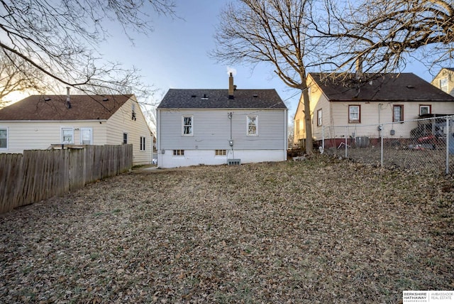 rear view of property featuring a fenced backyard, a chimney, and central AC unit