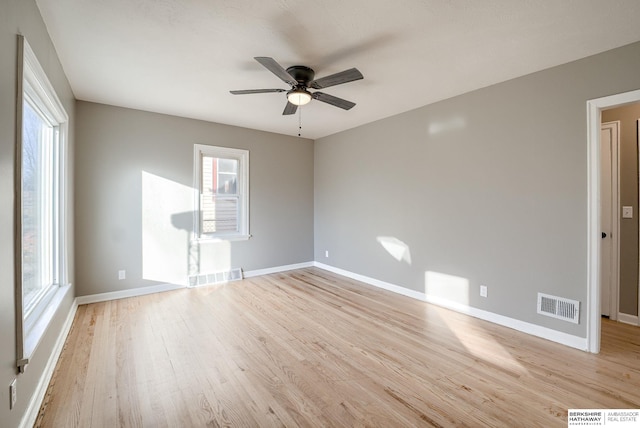 unfurnished room with a ceiling fan, baseboards, visible vents, and light wood finished floors