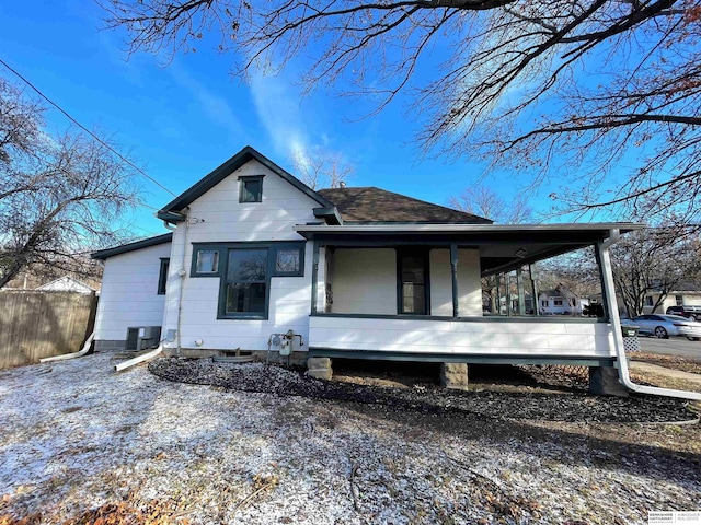 view of front of property featuring roof with shingles and fence