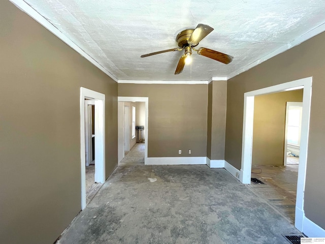 spare room with ceiling fan, ornamental molding, visible vents, and baseboards