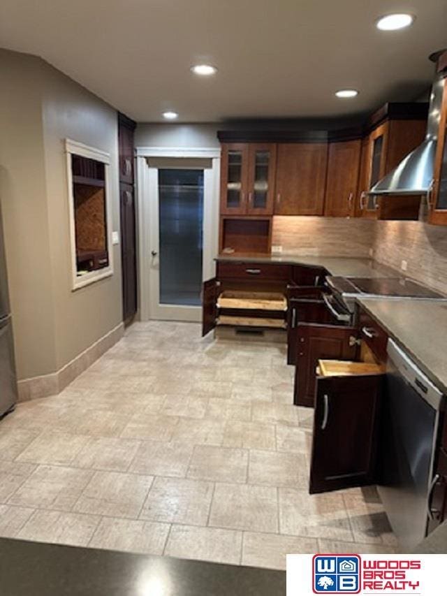 kitchen with wall chimney exhaust hood, glass insert cabinets, and recessed lighting