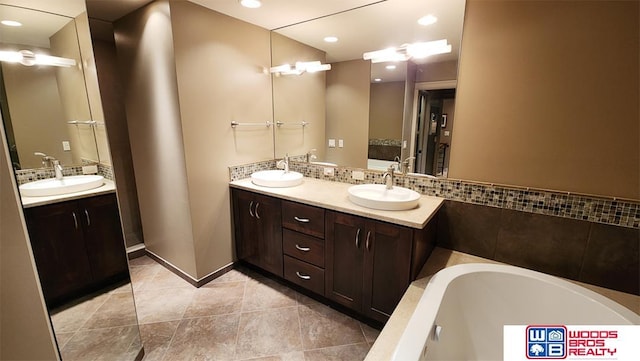 full bathroom featuring a sink, a bathing tub, and double vanity