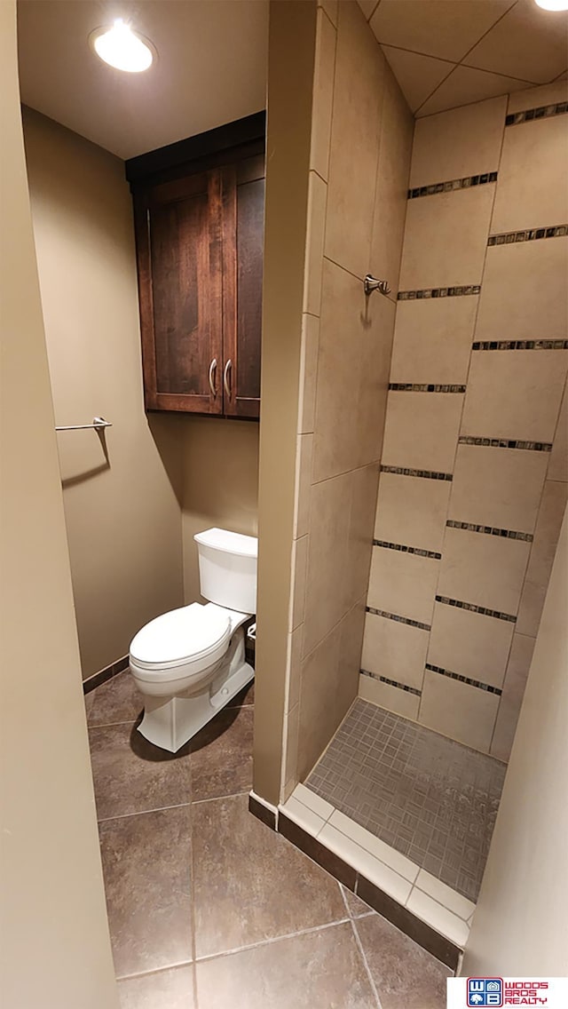 full bath with baseboards, a shower stall, toilet, and tile patterned floors