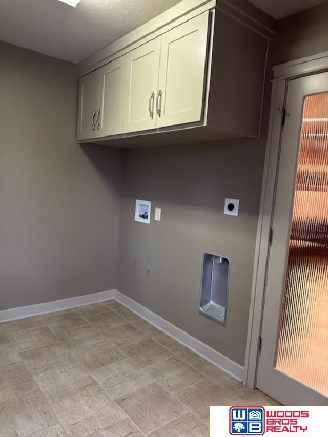 laundry area with cabinet space and baseboards