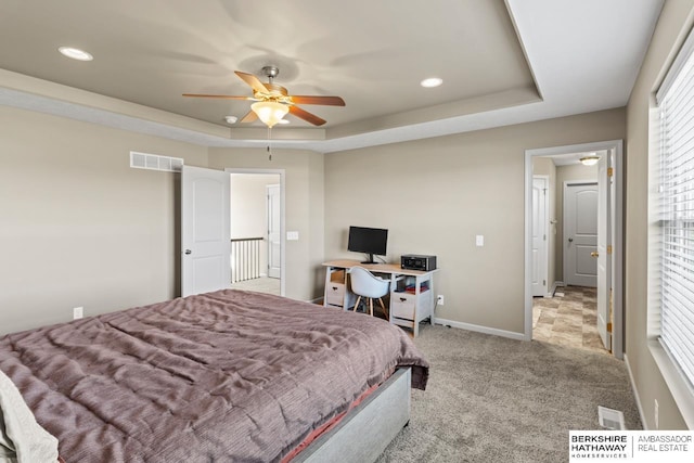 bedroom featuring carpet floors, recessed lighting, a raised ceiling, visible vents, and baseboards