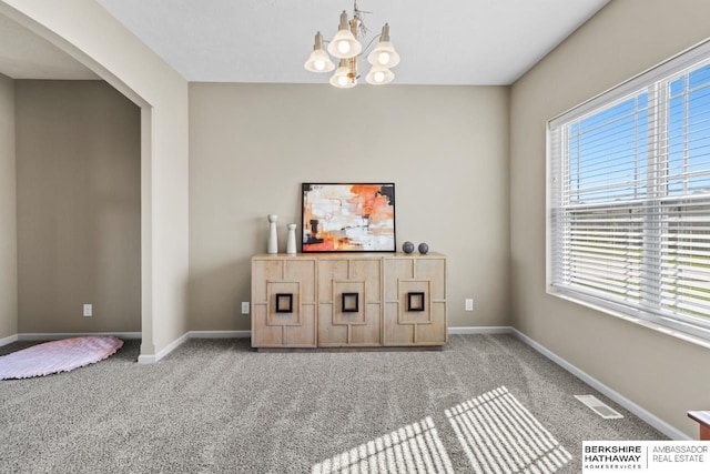 bar featuring carpet floors, visible vents, a notable chandelier, and baseboards