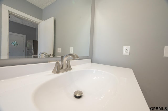 bathroom with a textured ceiling and vanity