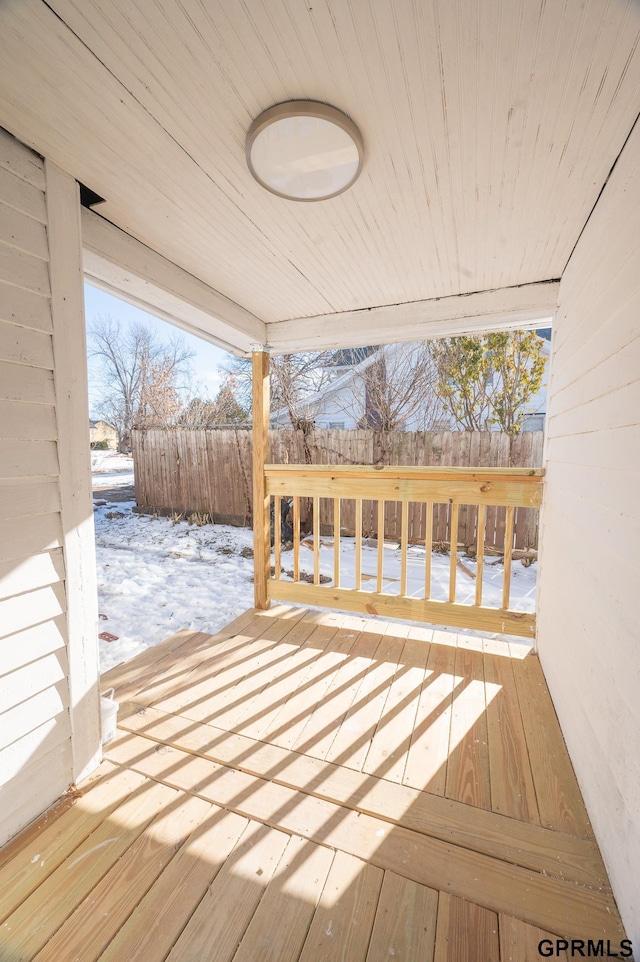 snow covered deck with fence