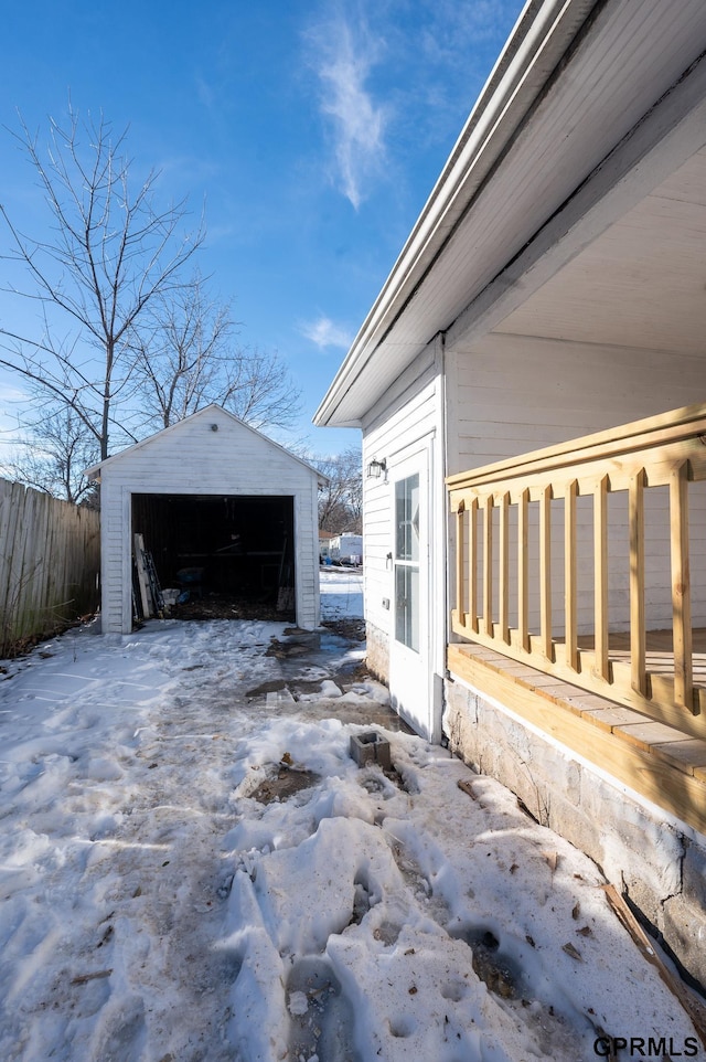 exterior space featuring a garage, fence, and an outbuilding