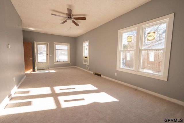 empty room featuring a textured ceiling, ceiling fan, carpet, and baseboards