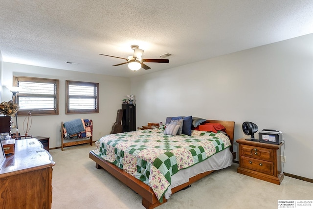 bedroom featuring a textured ceiling, ceiling fan, light colored carpet, visible vents, and baseboards