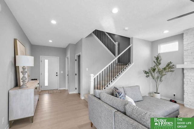 living area featuring light wood-type flooring, baseboards, stairway, and recessed lighting